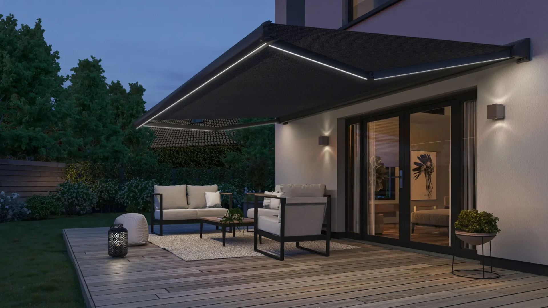 Mörk terrassmarkis med LED-belysning över ett trädäck med loungemöbler på kvällen